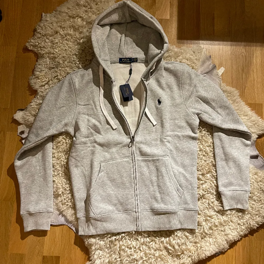 Introducing a pristine gray Polo Ralph Lauren zip-up cardigan, impeccably maintained at a flawless 10/10 condition and still adorned with its original price tag. . Tröjor & Koftor.