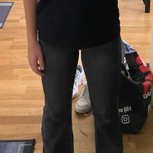 Svart-gråa lågmidjade bootcut jeans  - Snygga sitter jättebra. Stretch på byxorna. Inga syndloga skador. Lite urtvättade. Passar för storlek M också. Vid frågor kontakta mig.