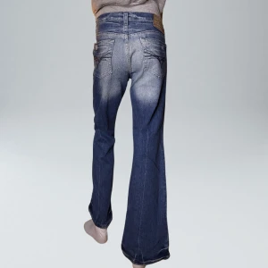 Lågmidjade Vintage Bootcut Jeans  - VARAN KAN KÖPAS DIREKT PÅ VÅR HEMSIDA, ettmarke.se MÄRKE: River Island. MODELL: Lågmidjade & Bootcut. FÄRG: Blå. STORLEK: 14 enligt lapp. Uppskattad storlek 40. MIDJA RAKT ÖVER: 42 cm. MIDJEHÖJD: 21 cm. TOTALLÄNGD (FRÅN MIDJAN): 94 cm. BENLÄNGD: 73cm