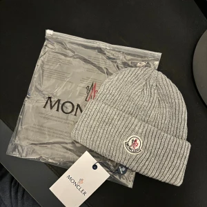 Moncler Mössa  - Moncler mössa i färgen grå helt ny