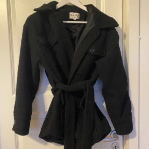 Svart kappa - Super fin skön kappa i storlek 36/S från nakd. Säljer denna jacka för den inte kommer längre till användning. Använt den sällan och är i god skick. Passar till höst, vinter och vår eftersom den är väldigt varm beroende på vad man har under.