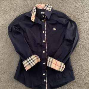 Burberry skjorta - Burberry skjorta storlek S, skicket är mycket bra, ny pris ca 5000 mitt pris är 900kr, hör av er vid frågor och funderingar