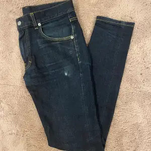 Ett ord snygga jeans från J.Lindeberg i Slim Fit modellen Jay. Mörkblå färg och har en slitning vid vänster framficka.  Storlek 31/34.