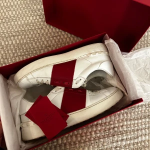 VALENTINO SKOR - Vit/röda supersnygga Valentino skor. Använda men i bra skick! Självklart äkta och orginlaförpackningen följer med. Storlek 39. Säljer dem då de inte kommer till användning längre. Kan skickas om köpare betalar frakt.  2500kr