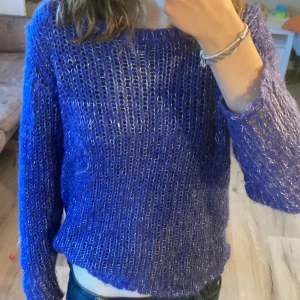 Blå glittrig genomskinlig stickad tröja  - Detta är en jätte fin stickad tröja med glitter. Den är genomskinlig som man ser på bild men ser super bra ut på. Har blivit använd ett få tal gånger. Kan tänkas gå med med pris vid snabb affär. Storlek S med skulle säga att den passa M också