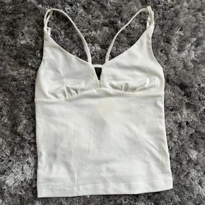 Vitt linne - Ett vitt oanvänt linne från Bikbok i storlek XS. Linnet har Justerbara band och fina detaljer med band som går diagonalt över bröstet. Säljer pågrund av att det inte kommit till användning. Köpt för 199 men säljer för 150 skriv för intresse❤️