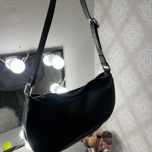 Svart liten väska  - Säljer denna svarta väska ifrån monki.  Använd 1 gång. Kom Orvar för att diskutera pris eller för fler bilder💕