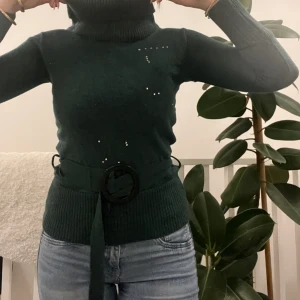 Grön stickadtröja - Grön stickadtröja med polokrage och bälte! Använd fåtal gånger, bra skick!  Från Motivi köpt i italien☺️ 