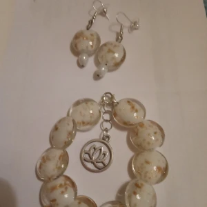 Armband med örhängen . - Armband med örhängen i materialet Glaspärlor med Guldglitter samt töjbar tråd .Elastisk .Egen design .