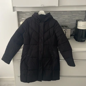 Mckinley dunjacka - Svart dunjacka. Köpt förra vintern. Ett litet hål längst ner på jackan, inget som syns. Luva. Annars fint skick. Storlek 36. Mckinley är märket. 