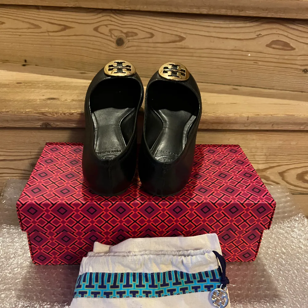 Fin begagnad ballerina från Tory Burch, populärt modell. Modellen kallas det: REVA BALLET, style nummer är 50008690 i Svart/Guld. Sälja med dustbag och i original skolådan. Gärna skicka ett mejl om önskar mer flera bilder av skorna. . Skor.