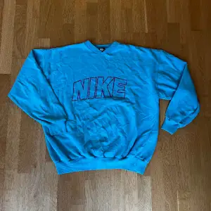 Vintage Nike tröja, i fint vintage skick = mindre defekter finns, men inget märkbart! Svårt att få med färgen på bild men den är ljusblå med rosa tryck! :)