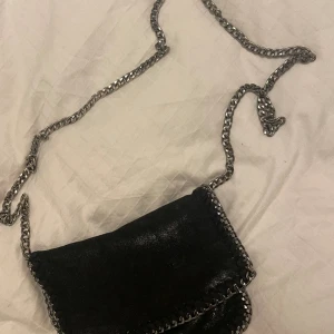 Väska med kedjor - svart väska med silverkedja. köpt second hand så vet inte vilket märke det är. Använd men i jättefint skick😊