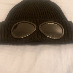 Cp Company Mössa  - Den är i väldig bra skick köpte den av en polare den är inte använd tror inte där är äkta men den liknar min äkta med qr kod på mössan. Om du vill veta mer skriv till mig.