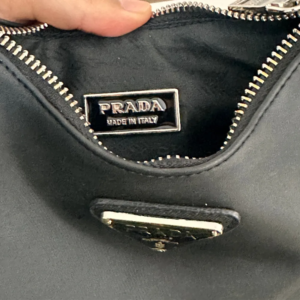 Hej säljer min Prada axelväska i svart. Den är i fint skick på utsidan, lite sönder i insidan men inget man tänker på. Därav priset. . Väskor.