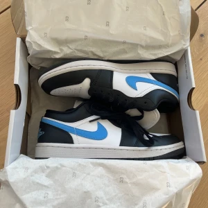 Air Jordan 1 Low ’Black University Blue White' restocks - Säljer ett par Air Jordan 1 Low ’Black University Blue White' som är helt nya , använda en gång. Köpta för 2500 kr. Storlek 39