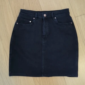 Svart jeanskjol H&M - Svart jeanskjol från H&M, strl 36. Endast använd en gång, säljes pga för liten strl. 