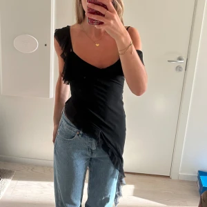 Asymmetriskt linne - Superfint asymmetriskt linne med volangdetaljer! Från Mistress Rocks! Aldrig använd och har därför prislapp kvar! Strl XS!