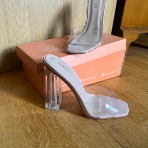 Clear sandal klackar (mules) - st 36 - Helt oanvända urläckra sommarklackar, köpta från Bebo, originalpris 500 SEK, ca 10 cm klack, säljer då jag köpte de precis innan covid och de därför aldrig kom till användning 