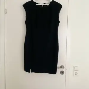Svart klänning i str 44 med liten slit, kort/mellan längd