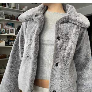 Säljer denna söta gråa pälsjackan från H&M. Som är i storlek XS, passar XXS och S också. Den har inga defekter och är knappt använd.