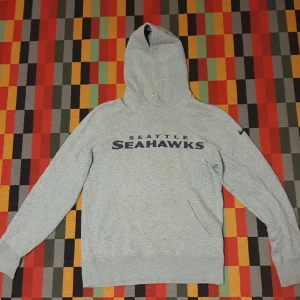 Vintage Nike Hoodie - Vintage grå nike hoodie. Köpt ifrån en secondhand-butik, storlek S. NFL laget Seattle seahawks på tröjan. Bara skriv om frågor angående passform och mått. 