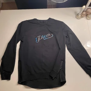 Svart Philipp plein sweatshirt - Tröjan är aldrig andvänd p.ga. Storleken, tröjan har korta dragkedjor på sidorna och är i ett mycket bra skick