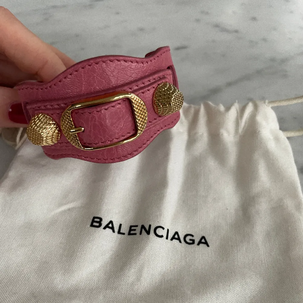 Rosa armband med guld detaljer från Balenciaga i nyskick. Inköpt från Vestire Collective (aldrig använd) så finns både äkthetsbevis & kvitto. Storlek S (20cm). . Accessoarer.