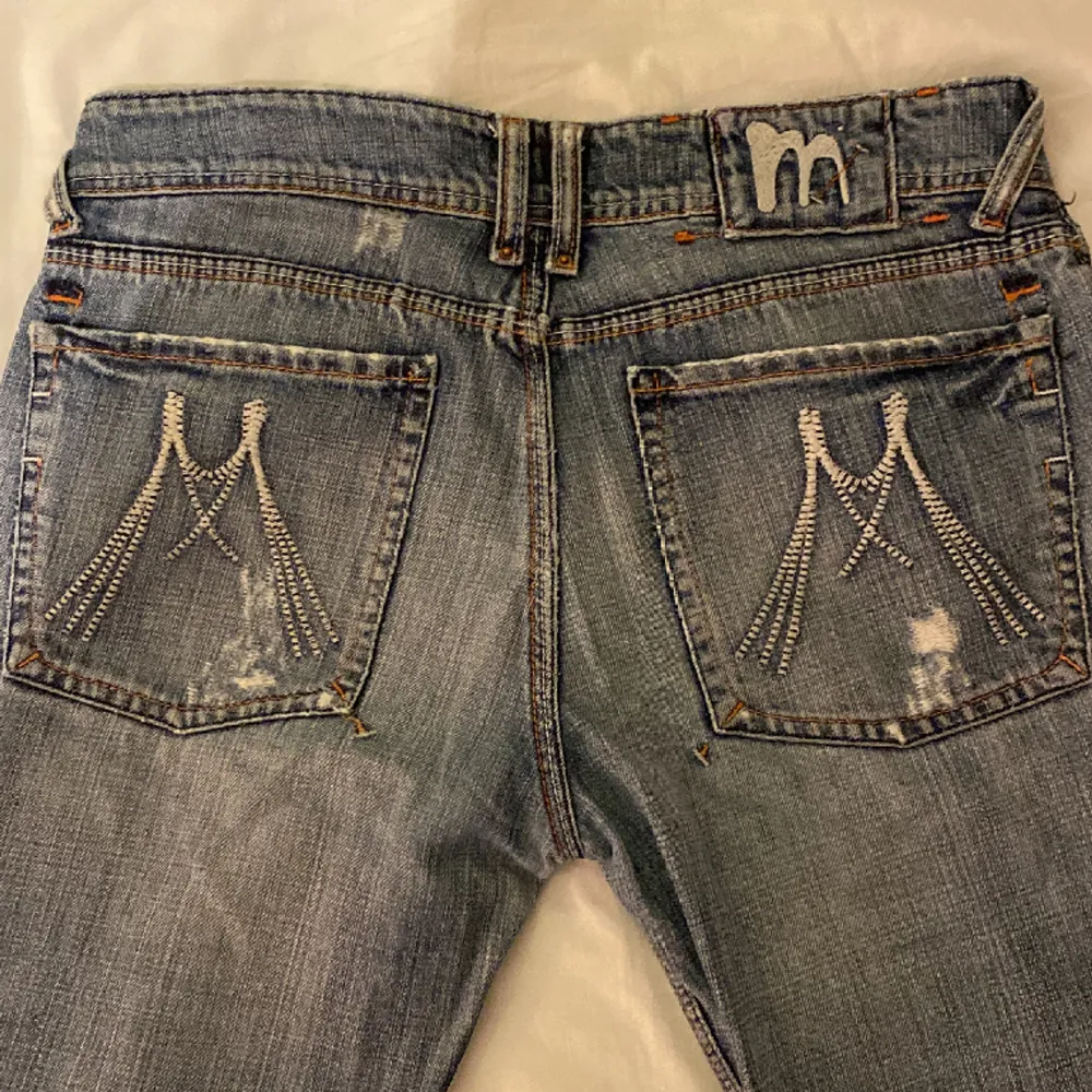 Ett par jättesnygga bootcut jeans med design på bakfickorna.. Jeans & Byxor.