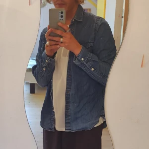 Jeansskjorta  - Jeansskjorta från H&M, i använt men gott skick utan hål men saknas knappar längst ut på skjortärmen. Storlek: S