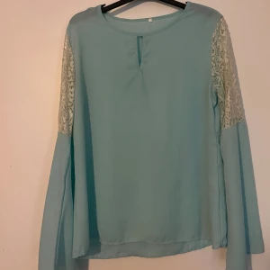 Blus - Blus med lite utsvängda armar o lite spetsdetalj på övre armen