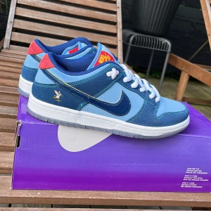 Nike Sb dunk - Säljer mina funka på grund av dem är för små, men får med extra snören i blå, har andvänt dem 3-4 gånger så den är nästan helt nya, dem är köpta på goat har kvittot till de, passar jätte bra nu i sommaren eller till hösten