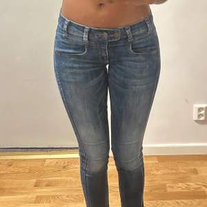 Snygga marinblå jeans med detaljer. Passar bra på 36. Innerbenslängd: 77cm.