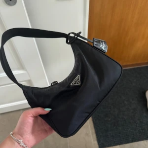 Äkta prada väska - Säljer denna perfekta Prada väskan! Köpt för några år sedan, men har inte använts på ett tag. Den rymmer mycket och är i väldigt bra skick! Nypris 11.500 kr och säljer för 5.000. Skriv för frågor mm.💗