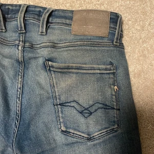 Replay Anbass jeans - Svinsnygga replay Anbass jeans i en snygg blå tvätt, nypris: ca 1500! Skick: 8/10 (liten defekt under gylfen, se bild 4)! Jag säljer jeansen för att det har blivit för små för mig! Obs är öppen för byten!