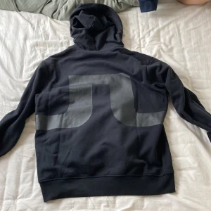 J.lindberg hoodie - Säljer min J.lindberg hoodie med tryck på ryggen. Skicket är som nytt inga defekter knappast använd, köpt i butik. Storlek M.