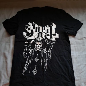 Ghost t-shirt - Säljs pga att jag inte lyssnar på bandet längre. Köptes oå EMP för ca 260kr. Storlek S. Har ett litet hål vid nacken (se tredje bild) annars perfect kondition.