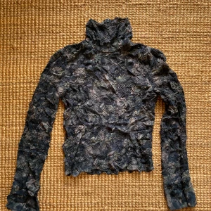 Blå polotröja från & Other Stories -  Polotröja från & Other Stories med ett unikt, skrynkligt mönster och vida ärmar nedtill. Knappt använd 💚