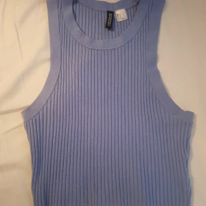 Fin blå topp - Säljer en ljus blå topp från h&m som är använd vid ett tillfälle och är tvättad en gång Myclet fin och sitter snyggt på!