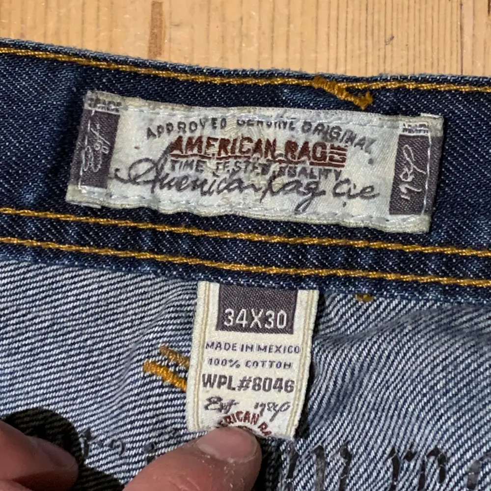 American Rag jeans i storlek W34/L30. Lite slitna längst ner. Jag på bilden är 180 cm. Mått: ytterbenslängd - 101 cm, midjemått - 45 cm, benöppning - 22 cm. Skriv för fler bilder och frågor!. Jeans & Byxor.