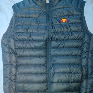 Ellesse väst  - Storlek Medium knappt använd, har alltid varit för liten för mig så säljer den nu, det enda defekta är att jag har tagit bort en text på ena sidan där det stog ELLESSE som jag inte tyckte var snyggt.  PRISET GÅR ATT DISKUTERA.  Mvh Harald