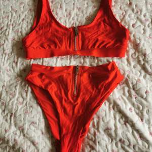 Bikini i stark röd färg! ❤️ Högmidjad underdel i brazilian cut. Verkar bara vara överdelen som dragkedjan går att dra ner på. Endast använd 1 gång, hoppas någon kan använda den mer! ❤️🌊