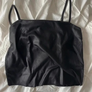 Svart topp  - Svart topp i glansigt material från Gina Tricot, tunt luftigt material.  