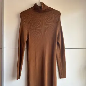 En brun, lång, fin klänning som är använd två gånger. Den går upp till halsen och passar perfekt till höst/vinter men även sommaren. Från Cubus och är i storlek M. 