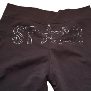 Star byxor - Ett par svart/mörkbruna byxor där det står "ST☆AR" på baksidan 💕 några av diamanterna har åkt av men annars i väldigt bra skick. Inga hål mm. Köpt på second hand men aldrig använda ❣️