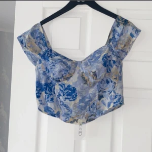 Korsett Topp  - Korsettopp från CIDER. Ny endast testad. Jäftefin, blom mönster, blå och ljusgul-ish. 