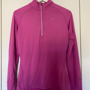 Träningströja Nike - Rosa träningströja från Nike i tunt material, dragkedja upptill. Storlek S, hyfsat figurnära passform.