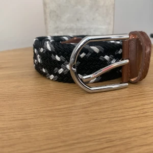 Flätat bälte  - Säljer mitt bälte för jag har två lika dana detta köpte jag för 199kr och jag har använt de 1 gång de är ett bra bälte i bra kvalitè bältet är svart, vit och grå bältet är 105 centimeter.  De är bara att skriva så fixar jag fler bilder. Mvh  Kasper 