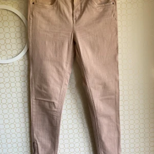 Skinny Regular Ankle Jeans -   Normalhög midja samt gylf med dragkedja och knapp. Kedjor i benslut. Ankellånga. En perfekt passform från morgon till kväll.