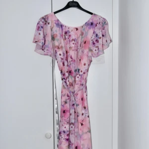 GODDIVA WRAP BACK FLUTTER SLEEVE DRESS - Säljer denna vackra blommiga klänning som är perfekt för våren och sommaren.  De 2 första bilderna är mina egna, de andra 2 är från GODDIVA’S sida.  Helt ny och är oanvänd.     